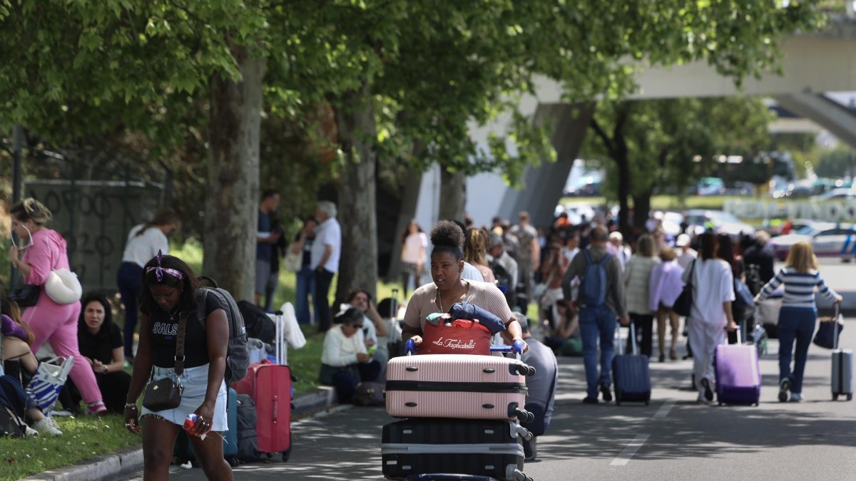 Los viajeros caminan hacia las salidas en el aeropuerto Humberto Delgado de Lisboa, ya que la zona está cerrada debido al apagón que afecta a España y Portugal, en Lisboa.