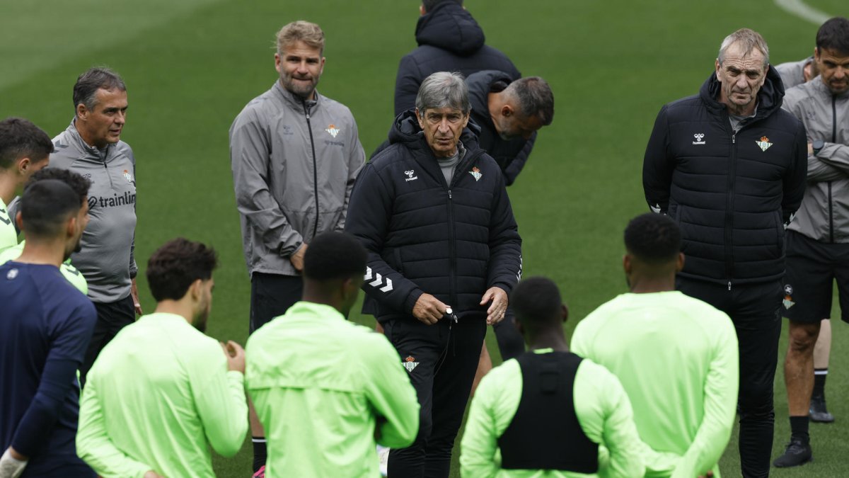 El entrenador del Betis (c), el chileno Manuel Pellegrini, habla con sus jugadores durante el entrenamiento realizado esta mañana de miércoles en Sevilla previo al partido que disputará ante la Fiorentina italiana mañana jueves en el Benito Villamarín de la capital hispalense, el primer asalto en busca de la gran final de la Liga Conferencia. EFE/Julio Muñoz