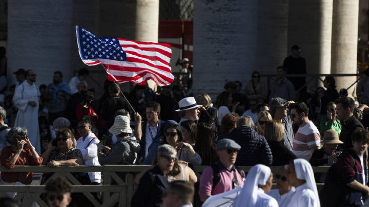 Una persona agita una bandera de Estados Unidos en la Plaza de San Pedro.