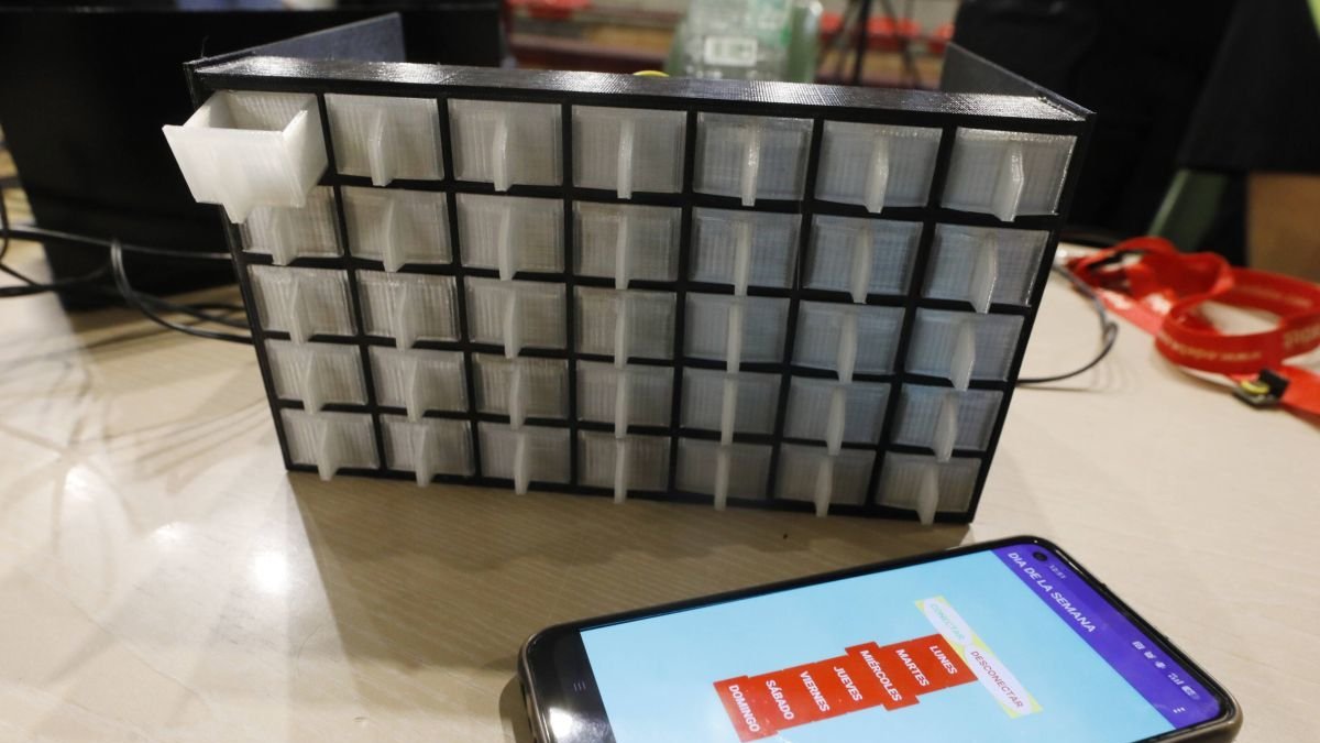 El dispensador automático con sus cajitas y el móvil.