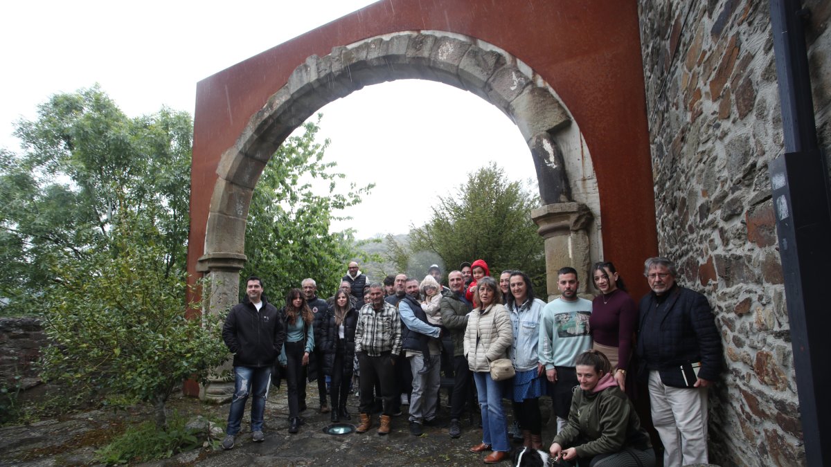 Nuevos y viejos vecinos de Santa Marina de Torre posan bajo el arco de la desaparecida iglesia de Santibáñez de Montes trasplantado al templo del pueblo.