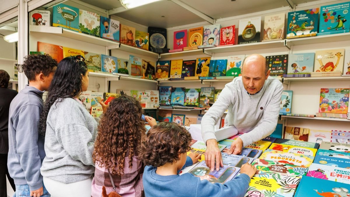 Unos niños mirando las novedades editoriales.