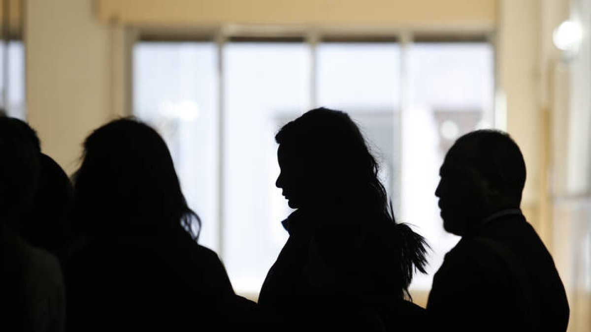 Personas hacen cola en una oficina de extranjería.