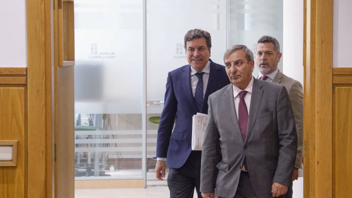 El consejero de Economía y Hacienda y portavoz, Carlos Fernández Carriedo (i), y el consejero de Movilidad y Transformación Digital, José Luis Sanz Merino (c) antes de comparecer en rueda de prensa posterior al Consejo de Gobierno.