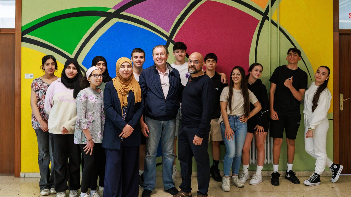 Loubna Yacini, Isidoro Herrero y Felipe Portillo, en el vestíbulo del instituto con alumnos de las tres clases de Religión.