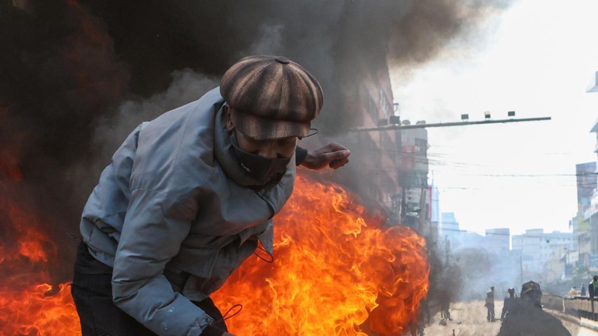 Un manifestante salta sobre neumáticos en llamas durante una protesta en el distrito central de negocios en Nairobi, Kenia, el 25 de junio de 2025, marcando el primer aniversario de las protestas de la Generación Z que culminaron con el asalto al parlamento nacional. (Protestas, Kenia) EFE/EPA/STR.
