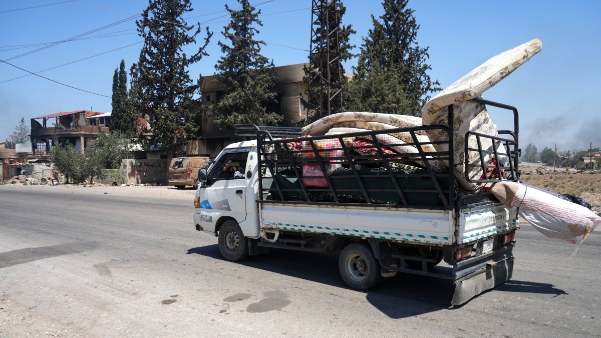 Una familia huye debido a los enfrentamientos entre tribus beduinas y facciones drusas locales, en la zona rural de Suwayda, en el sur de Siria.