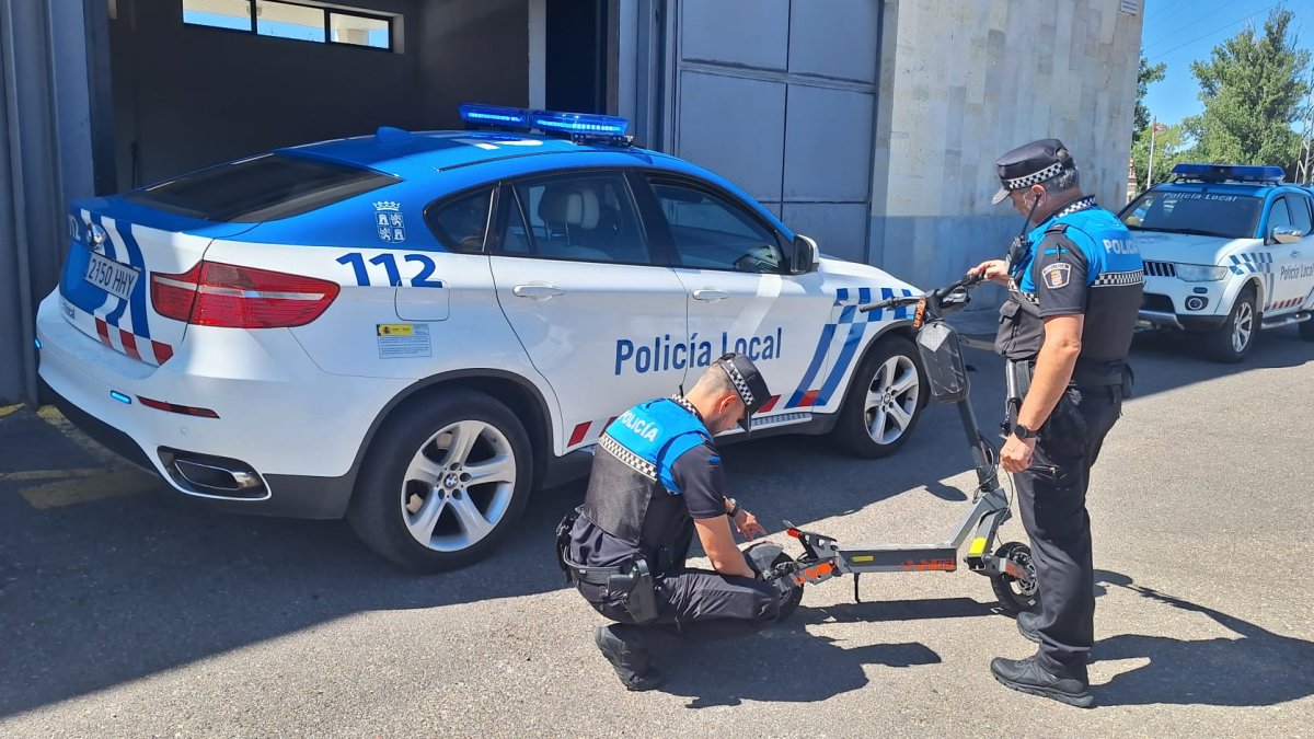 Los agentes inspeccionan uno de los patinetes intervenidos.