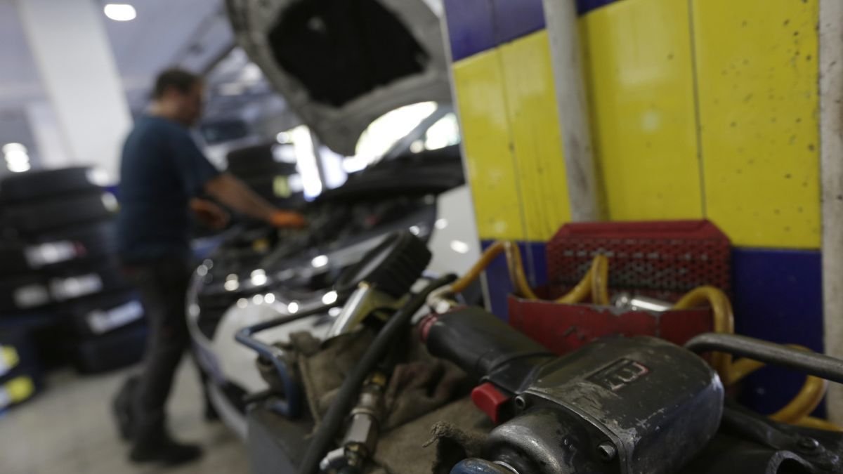 Un mecánico trabaja con un vehículo en uno de los talleres de la provincia de León.