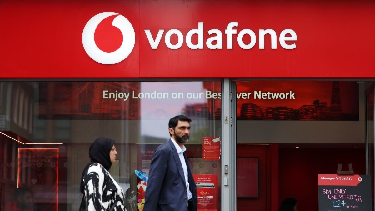 Una pareja ante una tienda de Vodafone.