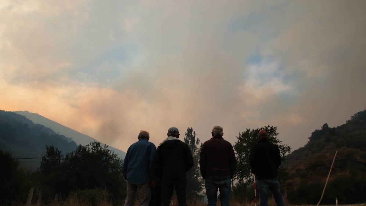 Varios vecinos contemplan el fuego del incendio de Boca de Huérgano.