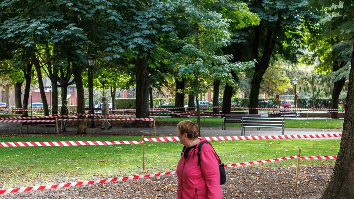 Una señora observa el cierre de parte de las zonas verdes por resiembra.