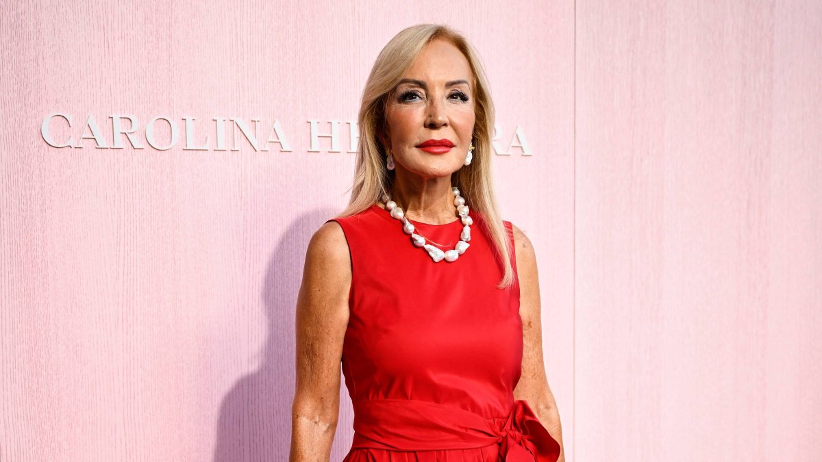 Carmen Lomana, con un vestido rojo de tafetán con lazada, en el histórico desfile de Carolina Herrera celebrado en la Plaza Mayor de Madrid.