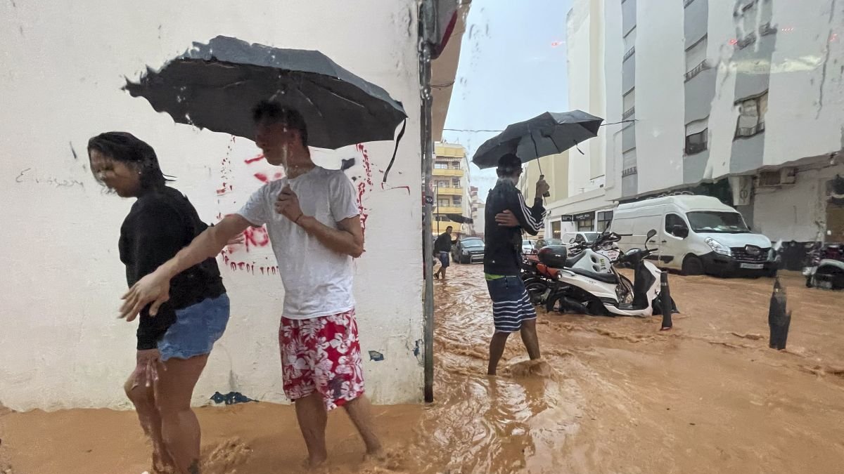 Personas caminan por calles anegadas en Ibiza.