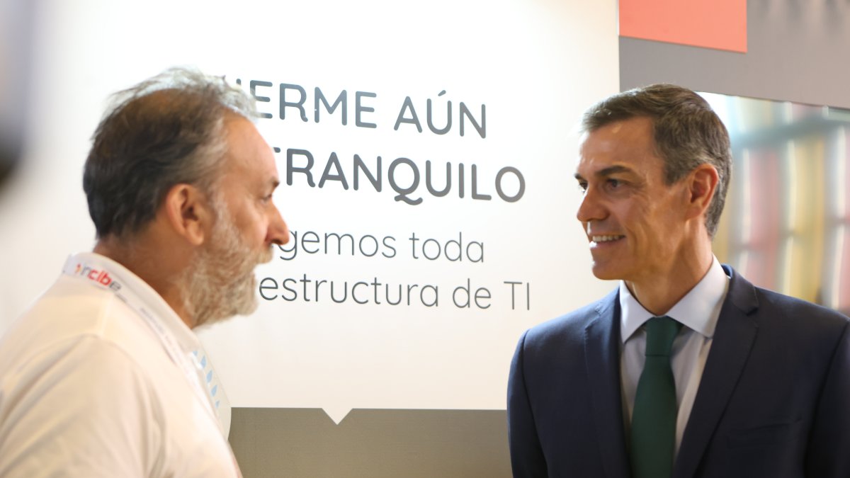 Sánchez, en el Palacio de Exposiciones, tras su llegada. El contraste de la imagen está en el mensaje escrito en el cartel.