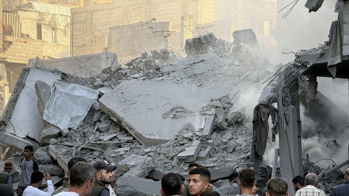 Un grupo de palestinos observa los escombros tras uno de los ataques lanzados por Israel ayer en Gaza.