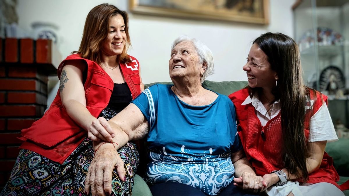 Voluntarias de Cruz Roja acompañan a una mujer.