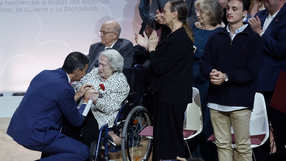 El presidente del Gobierno, Pedro Sánchez, saluda a María Luisa Ramos Barril, la única homenajeada que aún vive, durante el acto de homenaje a las víctimas y familiares del golpe militar, la Guerra Civil y el franquismo, con motivo del día en recuerdo a este colectivo fijado en la Ley de Memoria Democrática, que este año tiene lugar a pocos días del 50 aniversario de la muerte de Francisco Franco, este viernes en el Auditorio Nacional de Madrid.