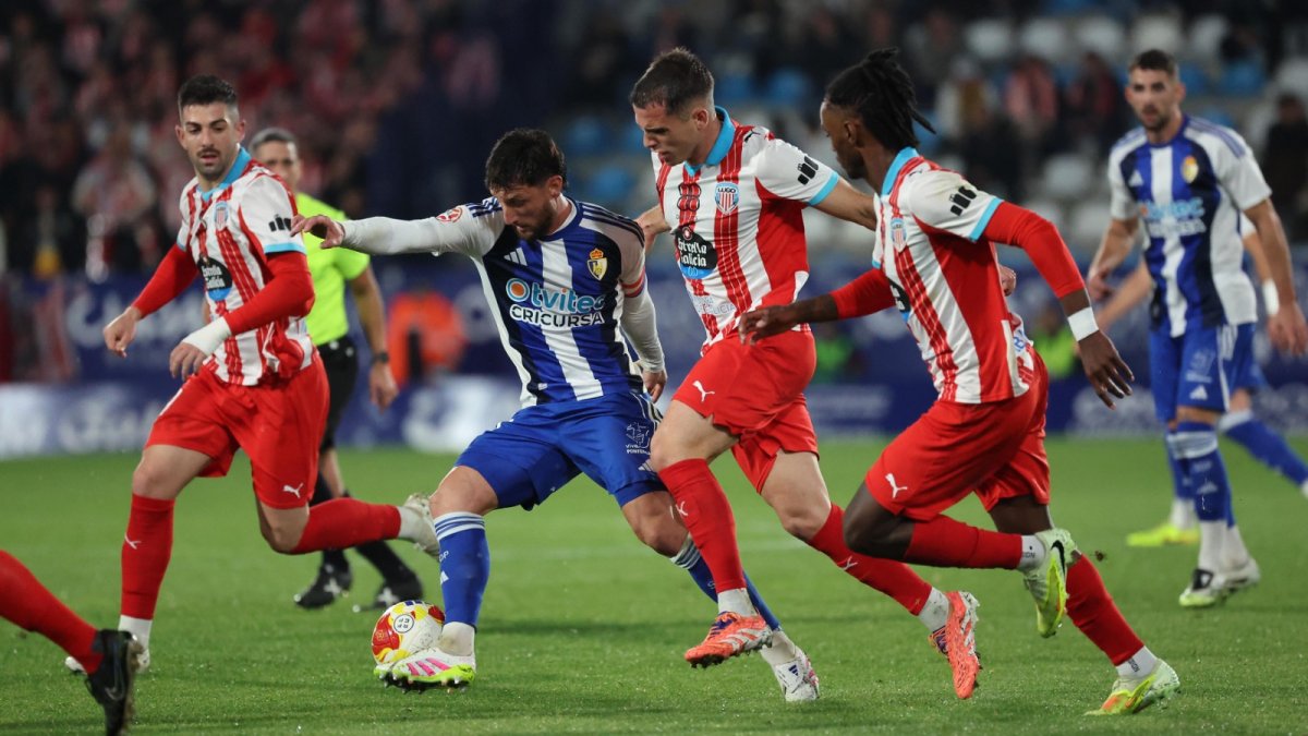Borja Valle controla el balón rodeado de contrarios del CD Lugo.