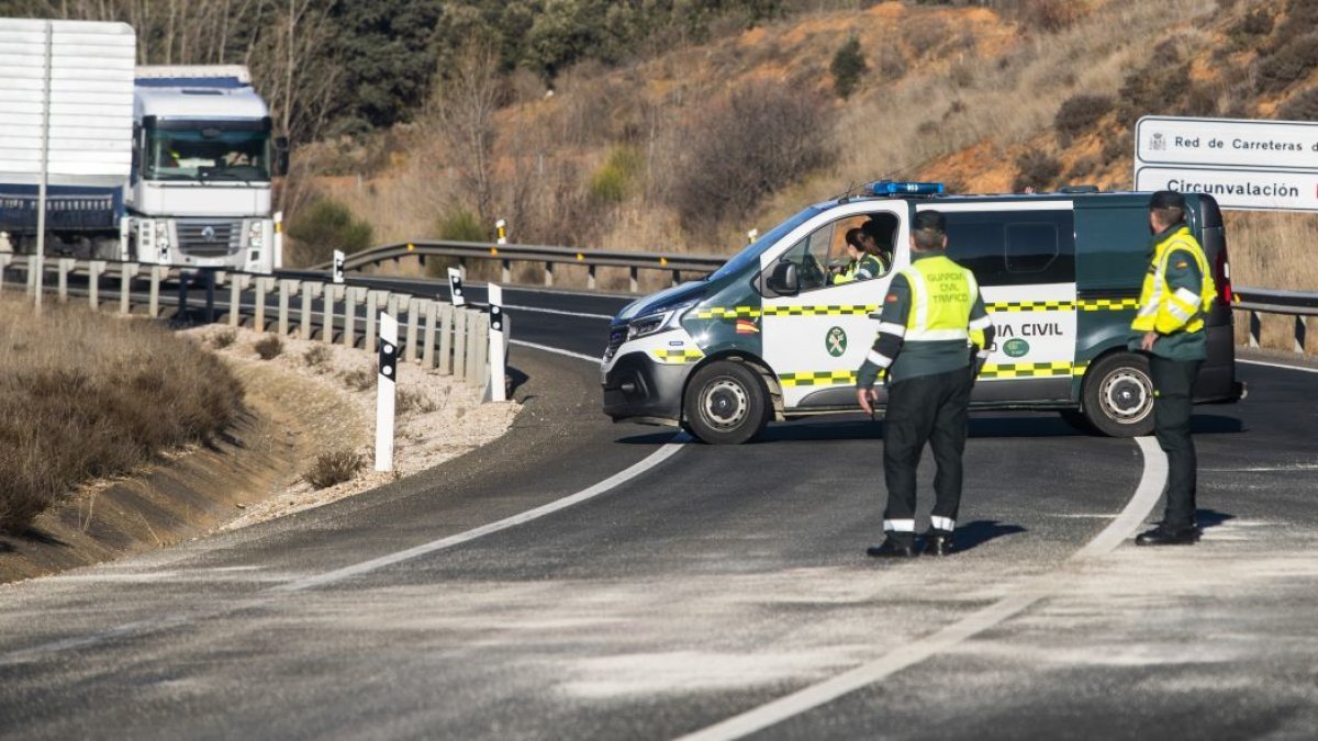 Agentes de la Guardia Civil regulan el tráfico en una carretera tras un siniestro con víctima mortal.