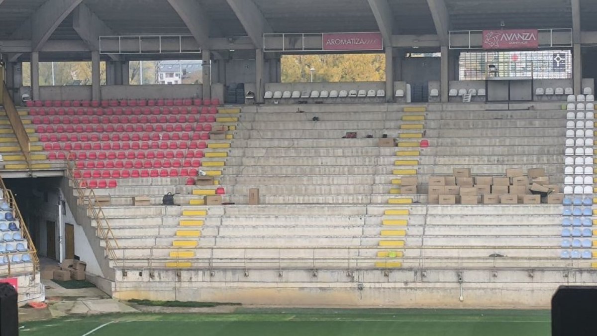 Imagen del cambio de los asientos viejos blancos y azules por los nuevos rojos del estadio Reino de León.