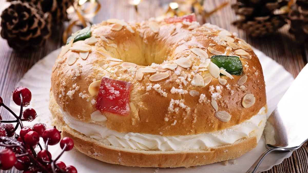 Roscón de Reyes tradicional relleno de nata, decorado con fruta escarchada y almendra laminada.