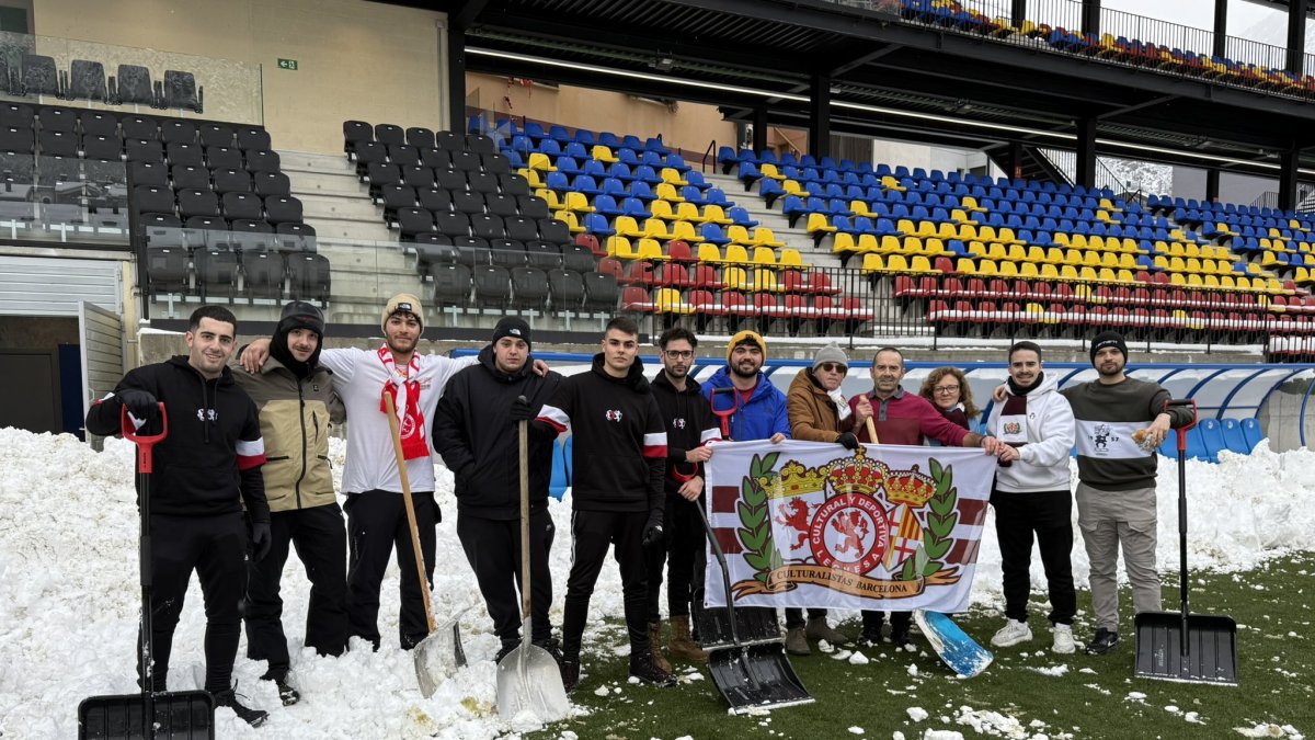 La afición leonesa ayuda a pie de campo en la retirada de la nieve.