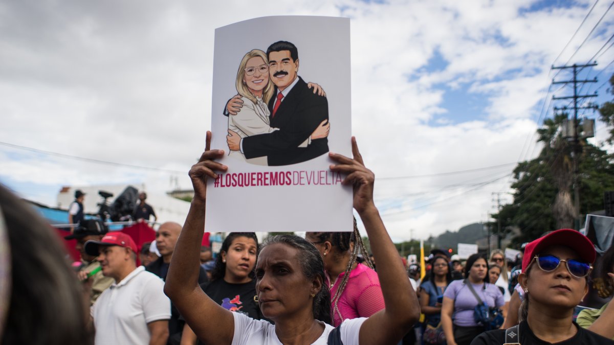 Una mujer sostiene un cartel durante una manifestación este sábado, en Caracas (Venezuela). Simpatizantes chavistas se movilizaron en distintas zonas de Caracas y en varias regiones de Venezuela para exigir a Estados Unidos la liberación y el regreso del mandatario Nicolás Maduro y su esposa, la diputada Cilia Flores, capturados hace una semana por fuerzas del país norteamericano en medio de una serie de ataques.