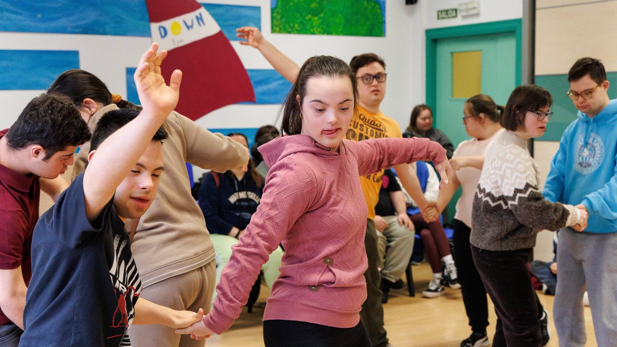 Pablo y Paula, pareja de baile en primer plano, con el grupo de Down León Amidown.