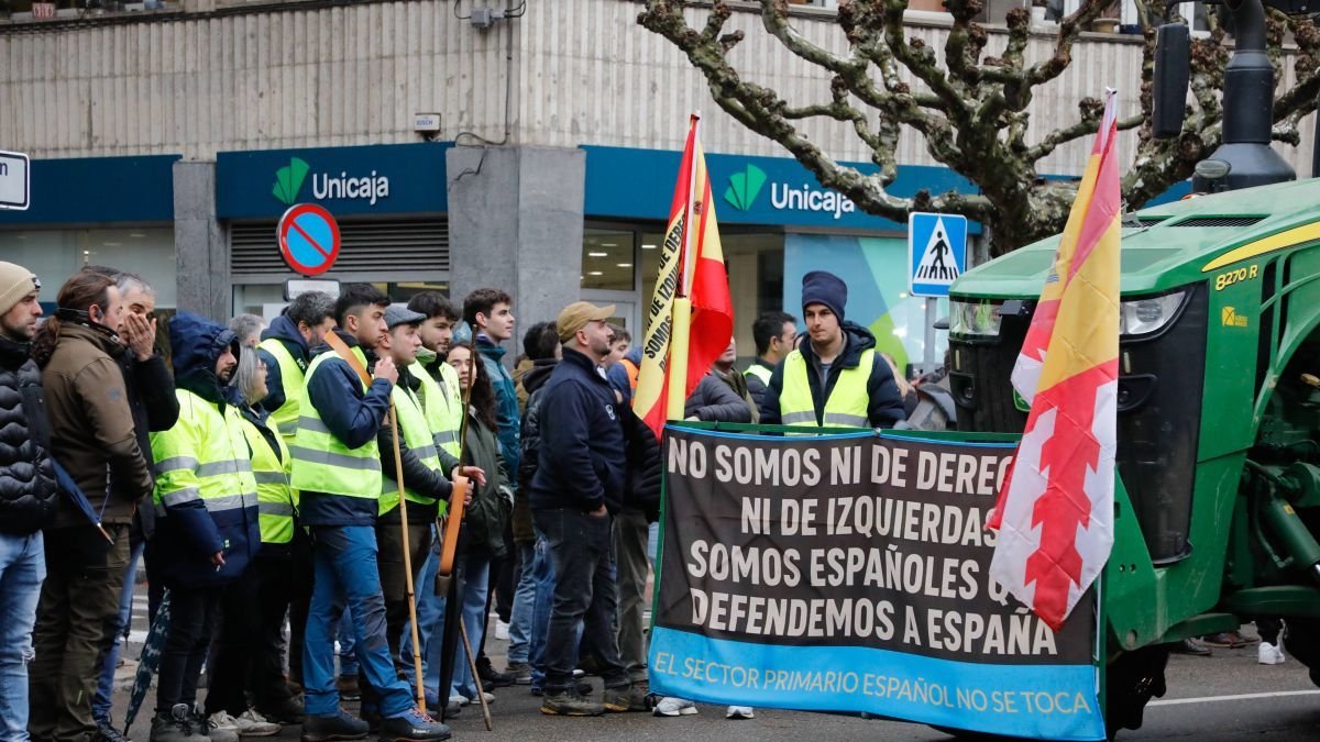 Manifestantes contemplan el paso de un tractor en la protesta de León.