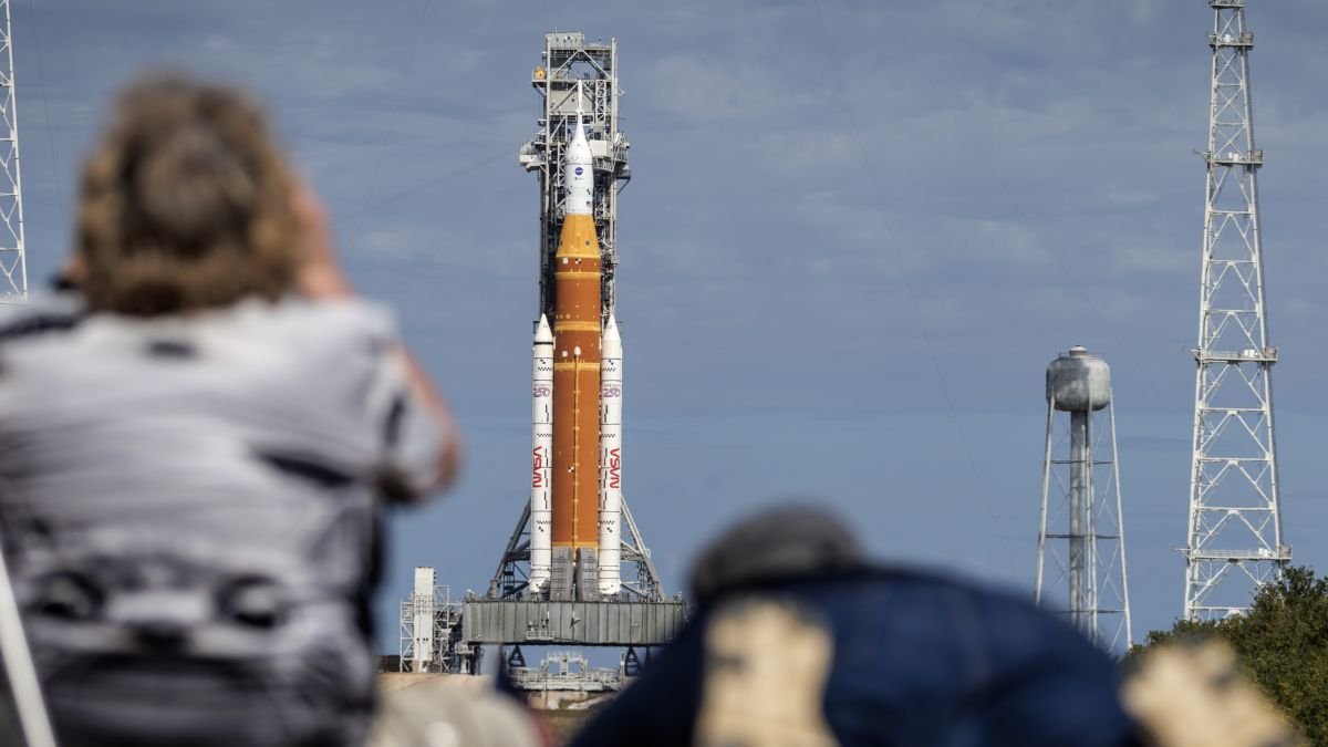 Fotógrafos de prensa toman imágenes del Space Launch System (SLS) con la cápsula de Orion.