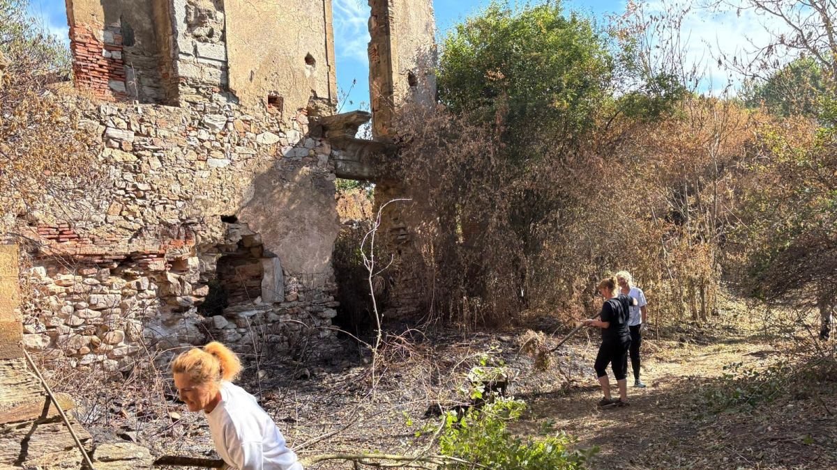 Vecinos ayudando a limpiar la zona afectada por los incendios. Montaña de ramas en los alrededores del monasterio.