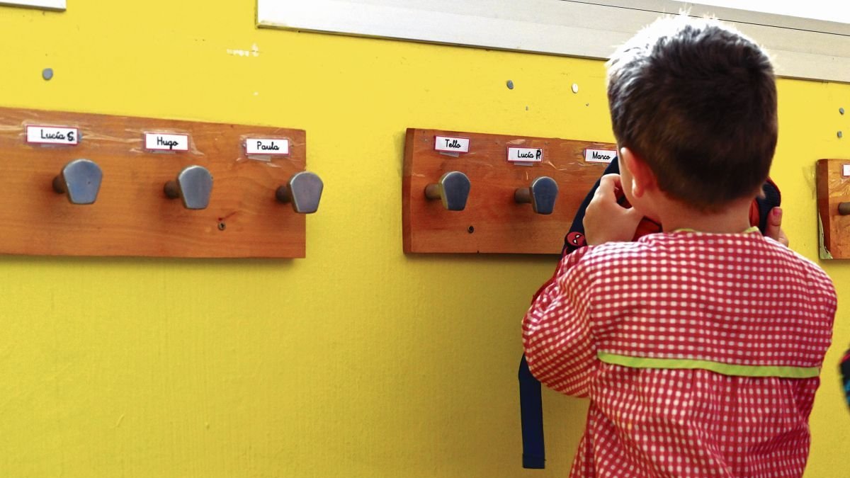 Un alumno cuelga su mochila en el perchero.