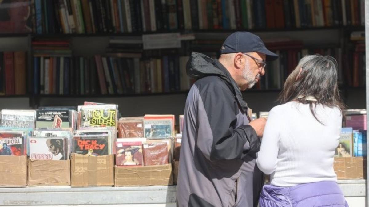 Visitantes revisan libros antiguos y descatalogados en una de las casetas de la Feria del Libro Antiguo y de Ocasión de Ponferrada