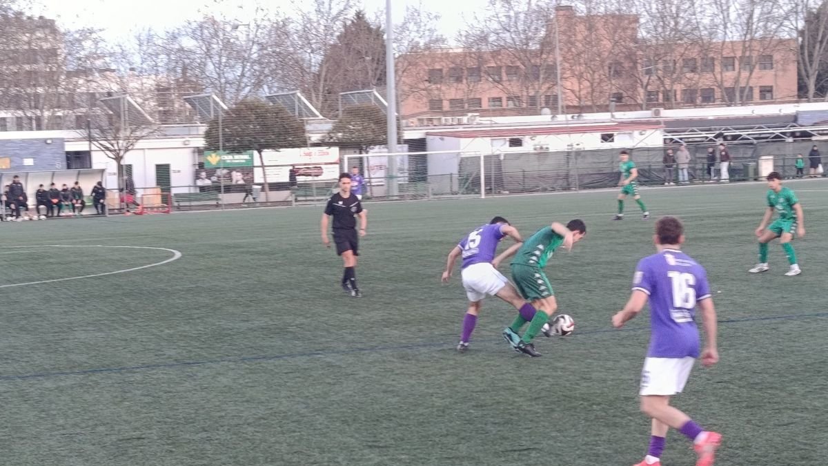 Un jugador bañezano lucha por recuperar el balón.