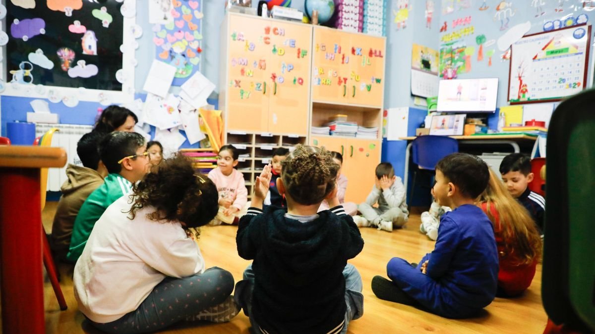 Varios niños y niñas con su profesora en una de las aulas del centro.
