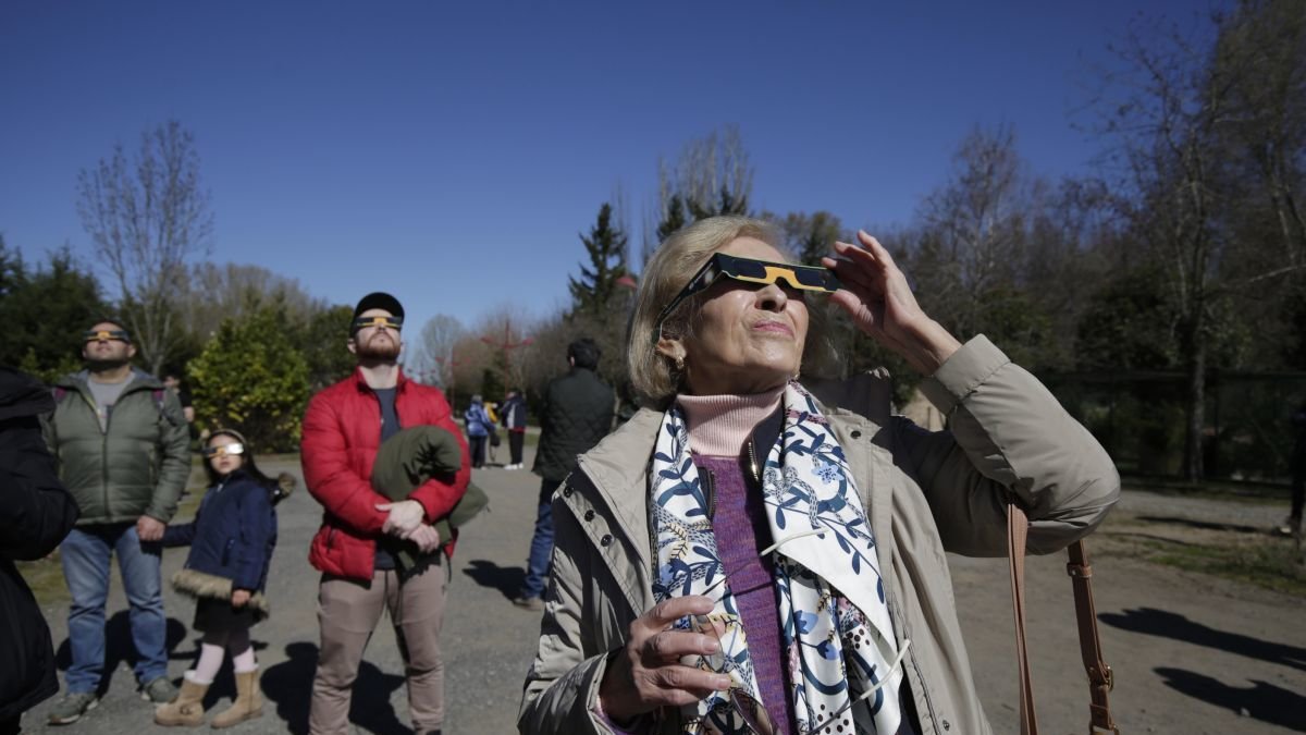 Varias personas observan un eclipse parcial de Sol en León.