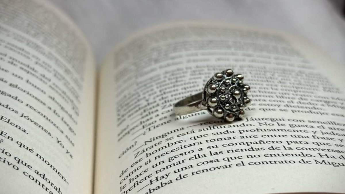 El botón charro, símbolo de protección y herencia cultural, reinterpretado en joyería contemporánea sobre un fondo literario