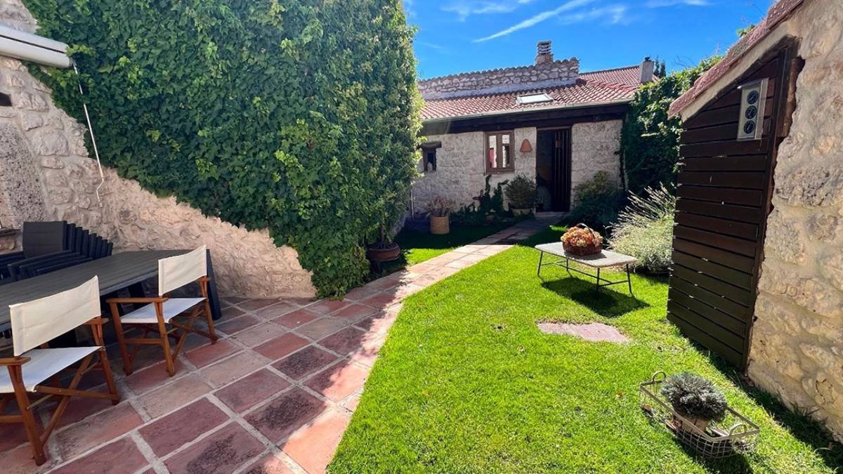 El exterior de la vivienda en Adrados (Segovia) combina jardín, terraza y zonas de descanso al aire libre