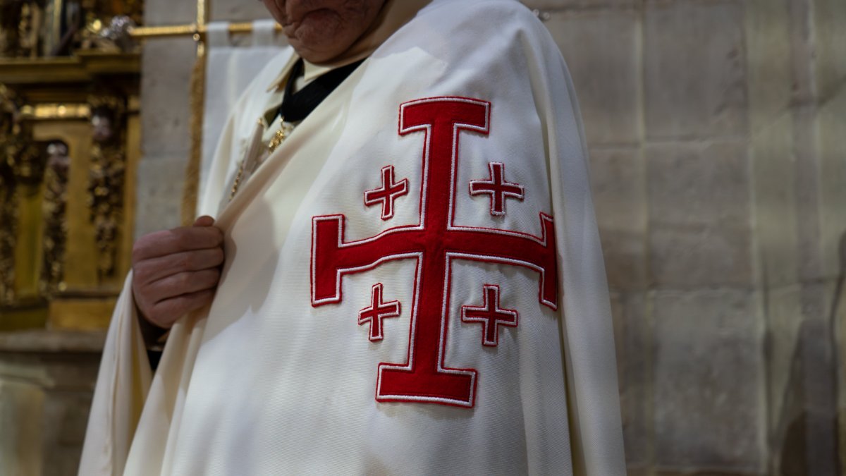 La capa corta de caballero con la cruz quíntuple potenzada, símbolo de las cinco llagas de Cristo y emblema distintivo del Santo Sepulcro de Jerusalén.