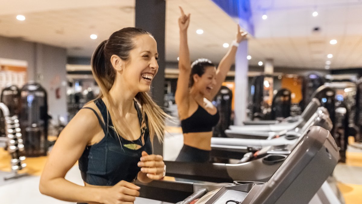 Dos mujeres corren en la cinta en un gimnasio