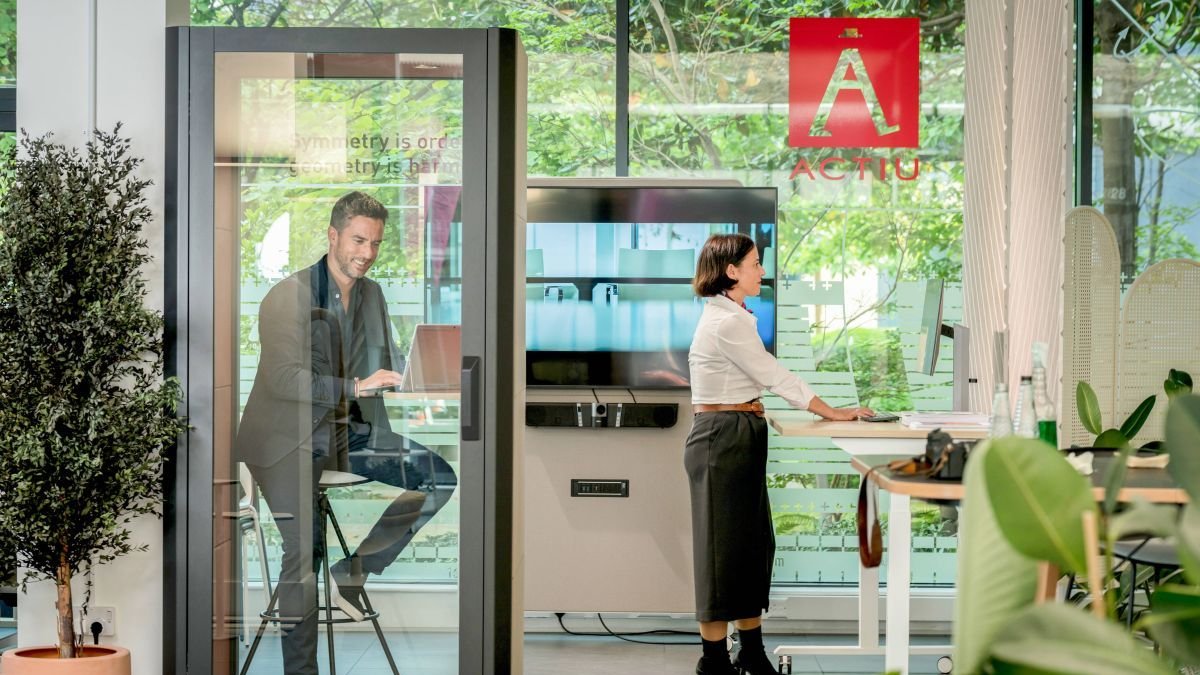 Dos personas trabajan desde su ordenador en un espacio de coworking.