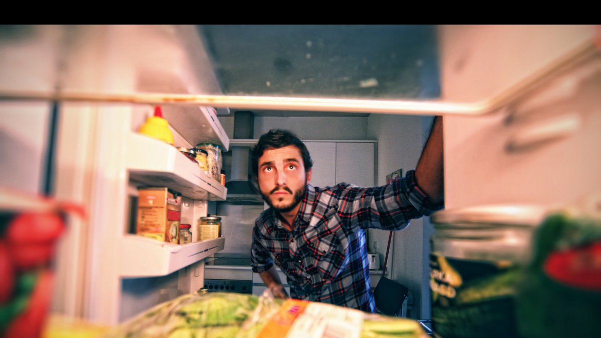 Un hombre mira el interior de un frigorífico