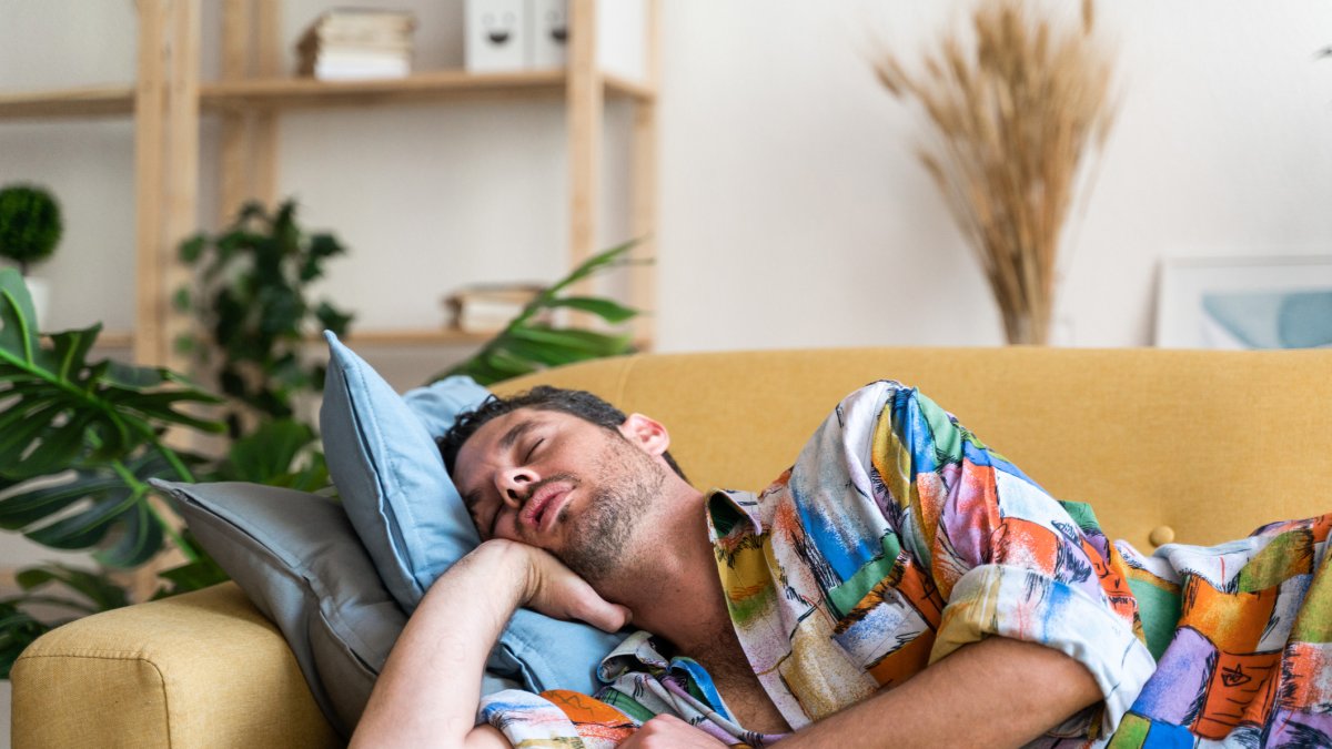 Un hombre se echa una siesta en el sofá de su casa