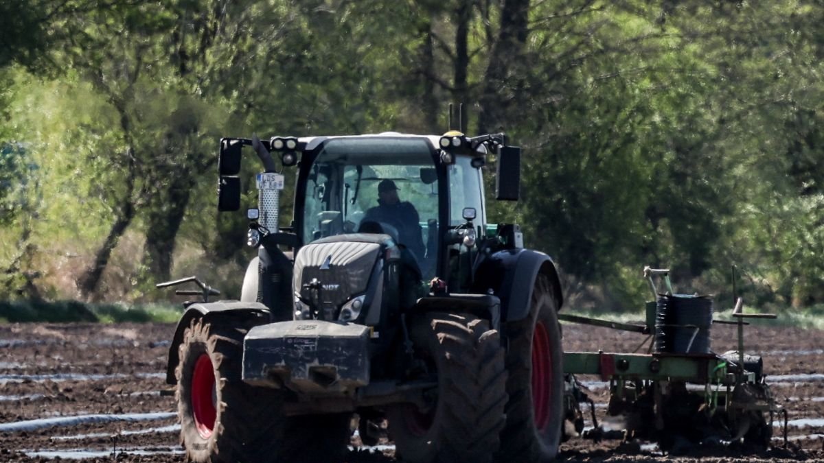 Un agricultor realiza labores de campo con su tractor.