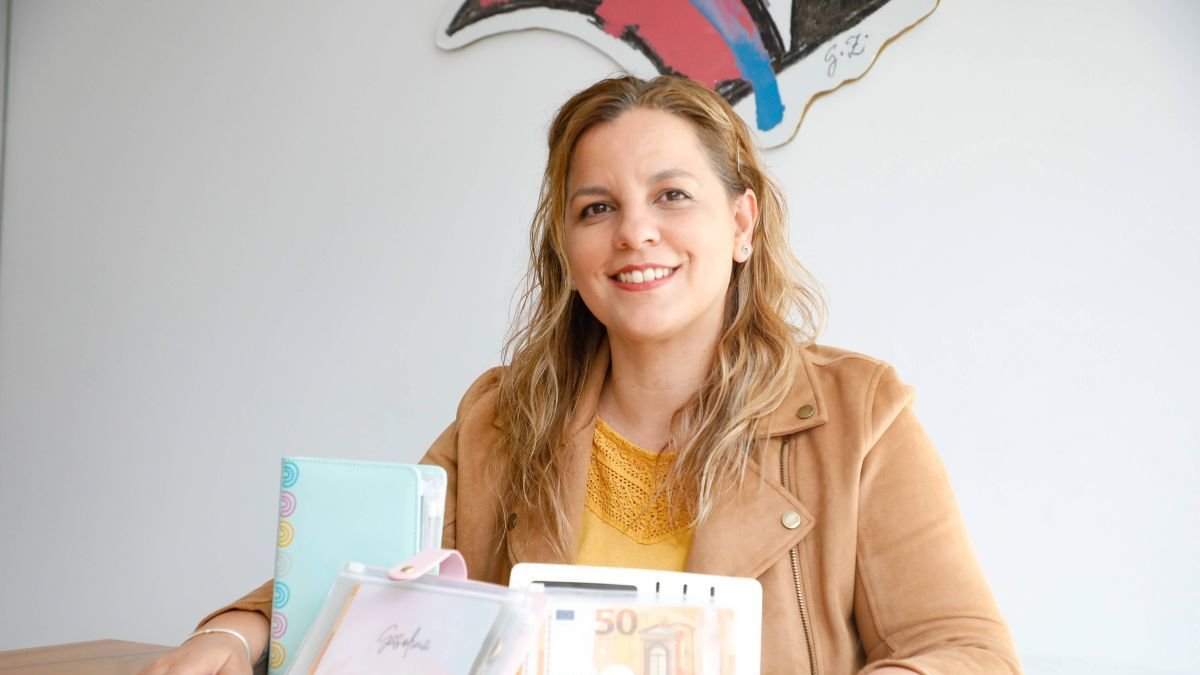 Ingrid Santos posa con las carpetas donde guarda el dinero físico compatimentado para los gastos.