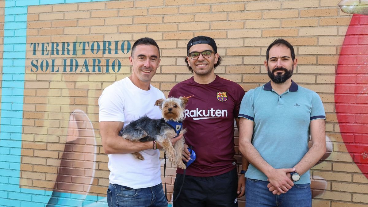 El perro Cooper, en brazos de uno de sus rescatadores, el policía local M.V., junto a su dueño y el otro agente héroe MÁ.N.