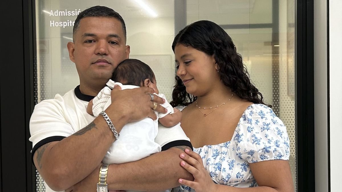 El bebé operado cuando aún estaba en el vientre de su madre, en los brazos de su padre.
