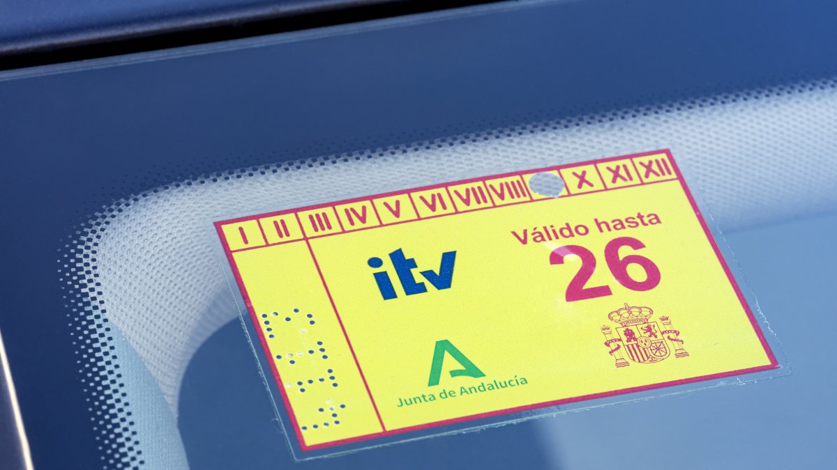 Pegatina española de inspección de vehículos ITV 2026 en el parabrisas del coche