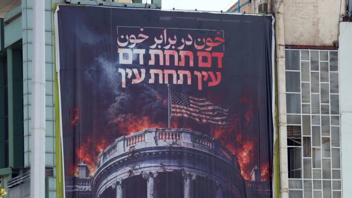 Una valla con la imagen de Trump y su familia en ataúdes con la bandera de EE UU.